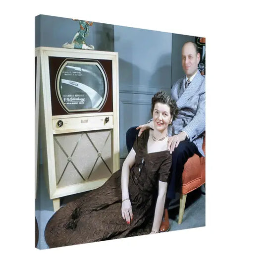 a man and woman sitting in front of a television